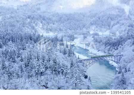 A three-car diesel train of the Tadami Line crossing the Tadami River when the water level was so low that snow piled up right up to the water's edge. A three-car diesel train of the Tadami Line crossing the Tadami River when the water level was so low that snow piled up right up to the water's edge. 139541105