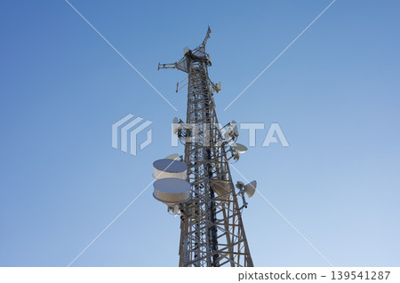 Telecommunications tower with satellite dishes against clear sky Telecommunications tower with satellite dishes against clear sky 139541287