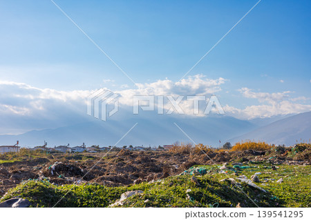 Sunlit mountain landscape with scattered debris in foreground Sunlit mountain landscape with scattered debris in foreground 139541295
