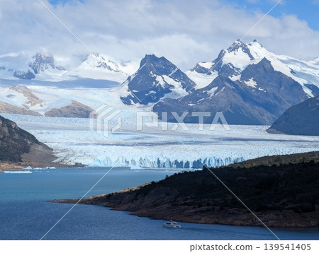 A view of the Andes peaks and a glacier in the Perito Moreno Glacier Valley in Santa Cruz Province, Argentina. A pleasure boat on the water. 139541405