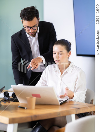Male manager helping to woman during working at laptop Male manager helping to woman during working at laptop 139541640