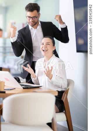 Man and a woman work in an office and are emotionally joy about the success in a new project 139541642