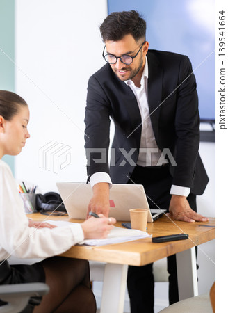 professionals working in a successful company, sit at a table professionals working in a successful company, sit at a table 139541664