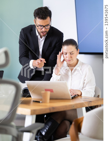 Male boss yells at woman employee, girl work at computer and reprimanded by management Male boss yells at woman employee, girl work at computer and reprimanded by management 139541675