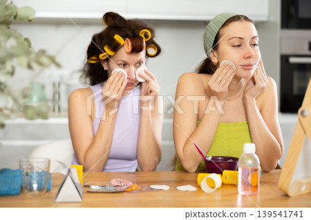 Two women cleanse their face with cotton pads 139541741