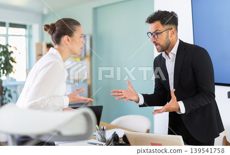 Quarrel between two managers in office - man and woman shout at each other, dissatisfied with their work 139541758