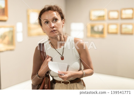 Young female visitor looking at exhibition in museum of ancient art Young female visitor looking at exhibition in museum of ancient art 139541771