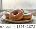 Glazed donuts on a plate by a window 139541878
