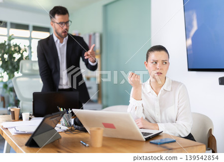 Male boss yells at woman employee, girl work at computer and reprimanded by management 139542854
