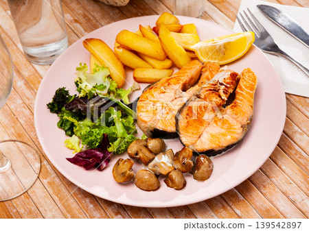 Fried salmon with fried potatoes and mushrooms, nobody Fried salmon with fried potatoes and mushrooms, nobody 139542897