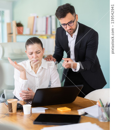 boss scolds at a woman who sits at the table and scrolls through social networks boss scolds at a woman who sits at the table and scrolls through social networks 139542941