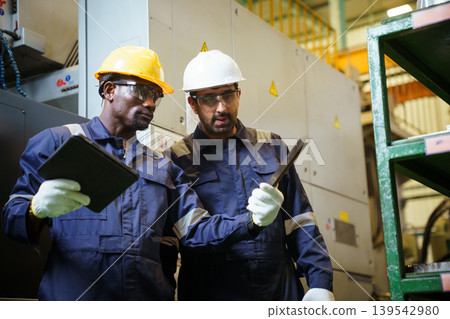 Engineers using tablet checking machinery in manufacturing factory Engineers using tablet checking machinery in manufacturing factory 139542980