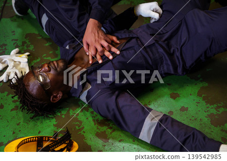 Emergency CPR by coworker after accident in industrial workplace Emergency CPR by coworker after accident in industrial workplace 139542985