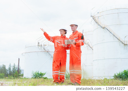 Two engineers surveying oil storage tank in energy plant Two engineers surveying oil storage tank in energy plant 139543227