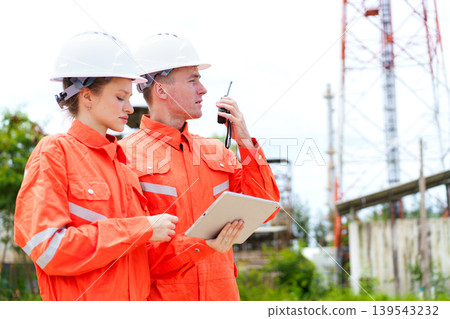 Engineers using tablet and radio at industrial site inspection 139543232