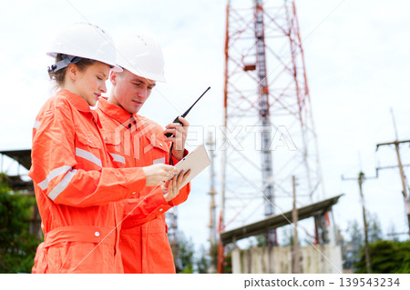 Engineers using tablet and radio at industrial site inspection 139543234