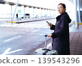 Asian woman with suitcase using smartphone at airport 139543296