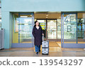 Asian woman with suitcase at airport terminal entrance 139543297