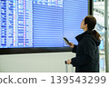 Asian woman looking at flight schedule board at airport 139543299