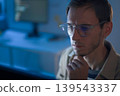 Software developer feeling stressed while working on programming code late at night 139543337