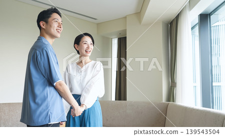 A couple looking out the window from their room. A couple looking out the window from their room. 139543504