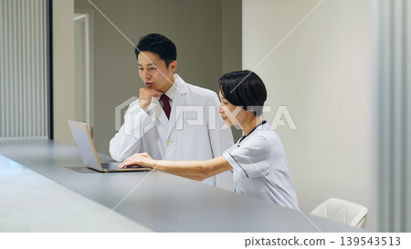 Female medical staff consulting with a doctor Female medical staff consulting with a doctor 139543513