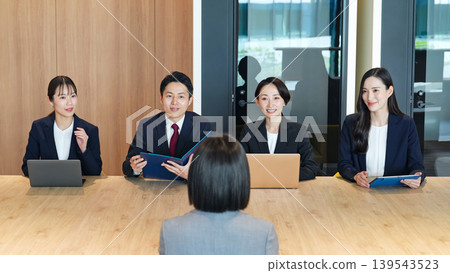A group of business professionals being interviewed in an office 139543523