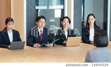 A group of business professionals being interviewed in an office 139543524