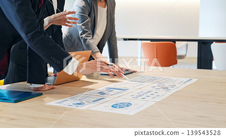A group of business people having a meeting while looking at documents in the office. A group of business people having a meeting while looking at documents in the office. 139543528