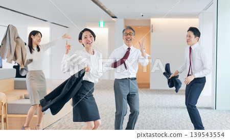 A group of male and female business professionals dancing in the office. A group of male and female business professionals dancing in the office. 139543554