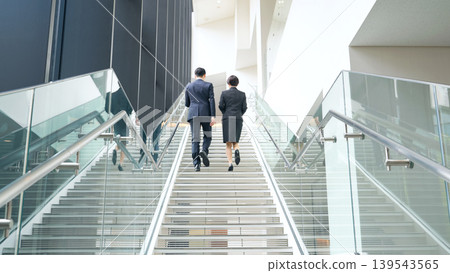 A group of male and female business people climbing the stairs A group of male and female business people climbing the stairs 139543565
