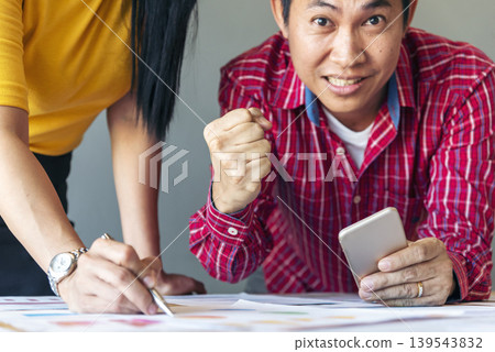Happy success business woman partner working together in company office corporate executive teamwork. Meeting Executive Asian business woman using laptop office desk with fist arm raised win happiness Happy success business woman partner working together in company office corporate executive teamwork. Meeting Executive Asian business woman using laptop office desk with fist arm raised win happiness 139543832