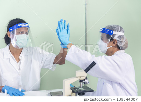 Two asian scientist men team high five partner shake hands together. Science Men research chemistry science experiment. Two men biotech coworker success greeting in laboratory. Teamwork successful Two asian scientist men team high five partner shake hands together. Science Men research chemistry science experiment. Two men biotech coworker success greeting in laboratory. Teamwork successful 139544007