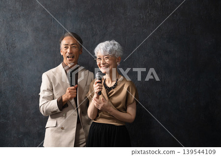 Senior men and women singing with a microphone Lifestyle image 139544109