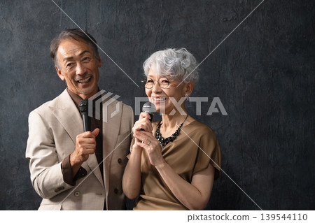 Senior men and women singing with a microphone Lifestyle image 139544110