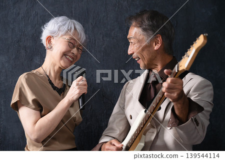A woman singing and a man playing the guitar Lifestyle image 139544114