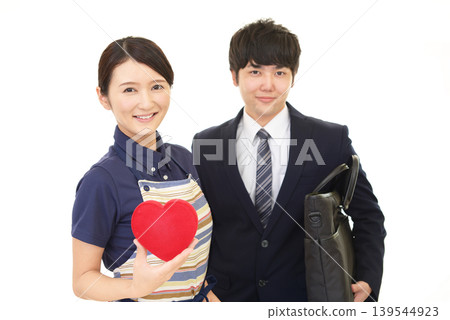 一對面帶著微笑的夫婦手持心型標誌 一對面帶著微笑的夫婦手持心型標誌 139544923