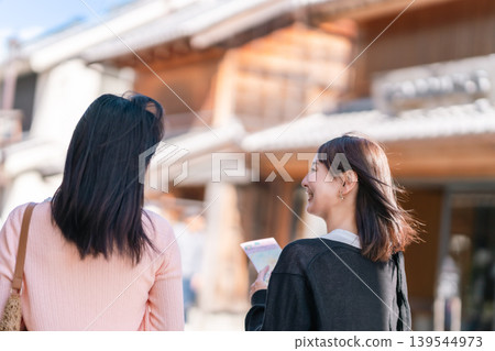 兩名年輕女子漫步街頭,背景是川越時之鐘。這是她們的埼玉縣之旅,在鎮上閒晃觀光。 兩名年輕女子漫步街頭,背景是川越時之鐘。這是她們的埼玉縣之旅,在鎮上閒晃觀光。 139544973