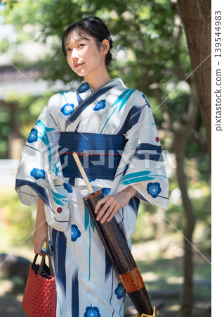 Japanese woman in yukata strolling through a garden: A Japanese-style portrait, a summer memory. Japanese woman in yukata strolling through a garden: A Japanese-style portrait, a summer memory. 139544983