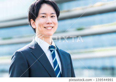一位笑容燦爛的年輕商務人士出現在辦公區。 一位笑容燦爛的年輕商務人士出現在辦公區。 139544991