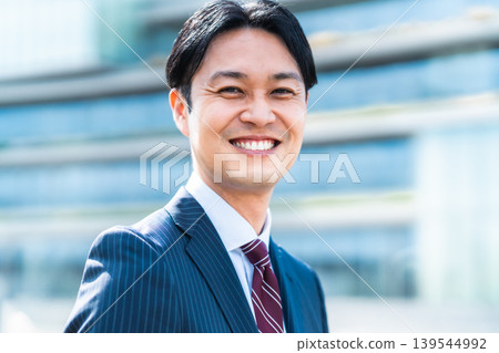 一位面帶自信笑容的中年商務人士出現在辦公區。 139544992