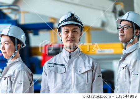 Construction and manufacturing teams project an image of reliability with heavy machinery in the background. Construction and manufacturing teams project an image of reliability with heavy machinery in the background. 139544999