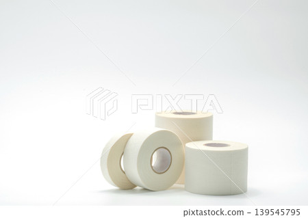 White sport tape roll isolated on clean white background representing athletic taping porous adhesive medical tape for wound care sprain support and first aid supplies in healthcare and fitness use. White sport tape roll isolated on clean white background representing athletic taping porous adhesive medical tape for wound care sprain support and first aid supplies in healthcare and fitness use. 139545795