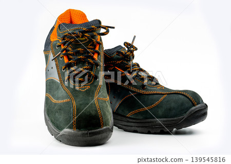 Pair of black safety leather shoes on white background, protective work footwear for men in factory or industrial environment. Oil and acid resistance. Workplace safety and accident prevention. Pair of black safety leather shoes on white background, protective work footwear for men in factory or industrial environment. Oil and acid resistance. Workplace safety and accident prevention. 139545816