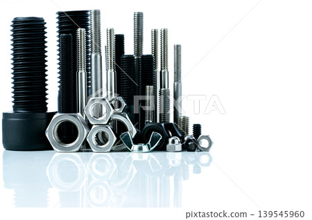 Metal bolts and nuts on white background. Fasteners equipment. Hardware tools. Stud bolt, hex nuts, and hex head bolts in workshop. Threaded fastener use in automotive engineering. Hexagonal bolt. Metal bolts and nuts on white background. Fasteners equipment. Hardware tools. Stud bolt, hex nuts, and hex head bolts in workshop. Threaded fastener use in automotive engineering. Hexagonal bolt. 139545960