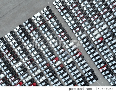 Aerial view of new cars stock at factory parking lot. Above view cars parked in a row. Automotive industry. Logistics business. Import or export new cars at warehouse. Big parking lot at port terminal Aerial view of new cars stock at factory parking lot. Above view cars parked in a row. Automotive industry. Logistics business. Import or export new cars at warehouse. Big parking lot at port terminal 139545968