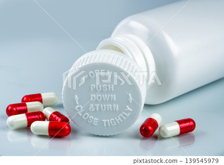 Capsules and pill bottle with child resistant push down and turn cap. Healthcare packaging design. Safety and protection. Pharmaceutical product. Preventing child access and ensuring secure storage. Capsules and pill bottle with child resistant push down and turn cap. Healthcare packaging design. Safety and protection. Pharmaceutical product. Preventing child access and ensuring secure storage. 139545979