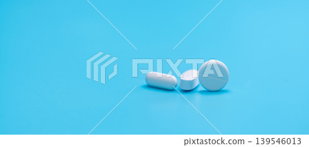 Round white tablets pills and oval tablets pills on blue background. Pharmacy shop banner. Prescription drugs. Pharmaceutical industry. Painkiller, antibiotics, and antacid tablet pills. Pharmaceutic. Round white tablets pills and oval tablets pills on blue background. Pharmacy shop banner. Prescription drugs. Pharmaceutical industry. Painkiller, antibiotics, and antacid tablet pills. Pharmaceutic. 139546013