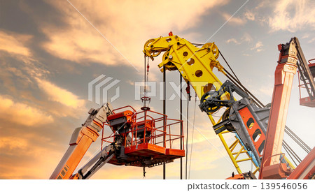 Articulated boom lift. Aerial platform lift and construction crane with sunset sky. Mobile construction crane for rent and sale. Maintenance and repair hydraulic boom lift service. Crane dealership. 139546056
