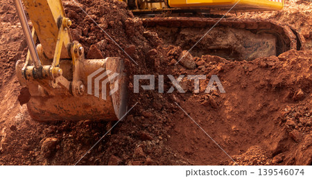 Backhoe working by digging soil at construction site. Bucket of backhoe digging soil. Crawler excavator digging on dirt. Excavating machine. Earth moving machine. Excavation vehicle. Trenching machine Backhoe working by digging soil at construction site. Bucket of backhoe digging soil. Crawler excavator digging on dirt. Excavating machine. Earth moving machine. Excavation vehicle. Trenching machine 139546074